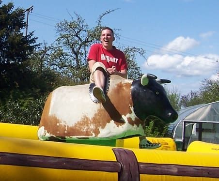 Eine Person reitet auf einem mechanischen Bullen im Freien.